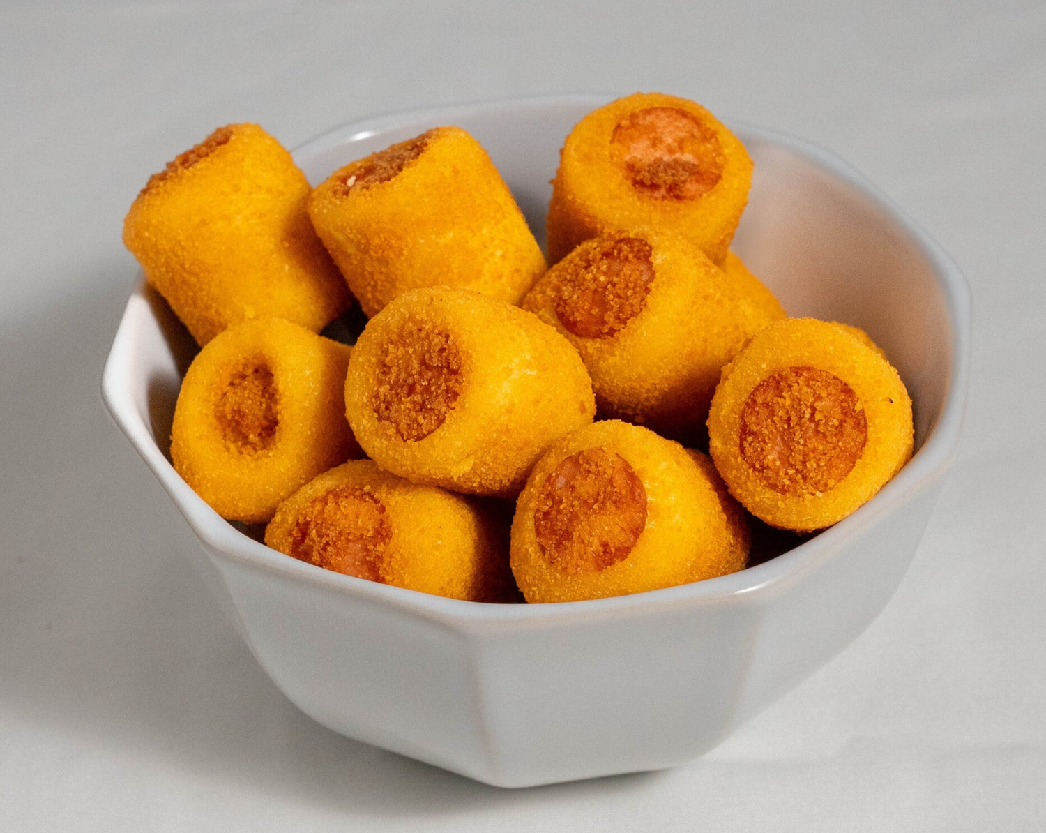 A party platter filled with golden mini Brazilian sausage rolls served hot, perfect for kids' parties and catering.