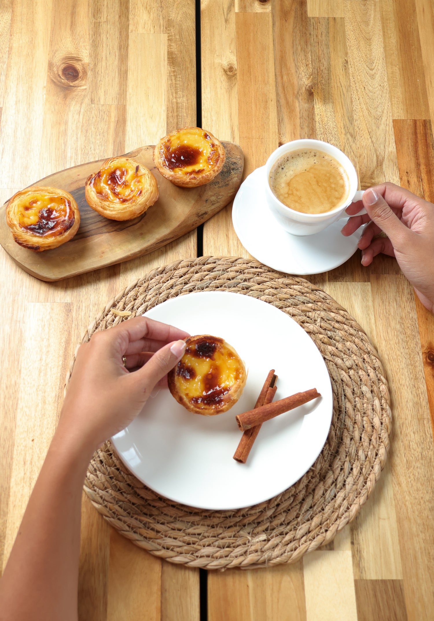 Portuguese pastries on a wooden table with a cup of coffee