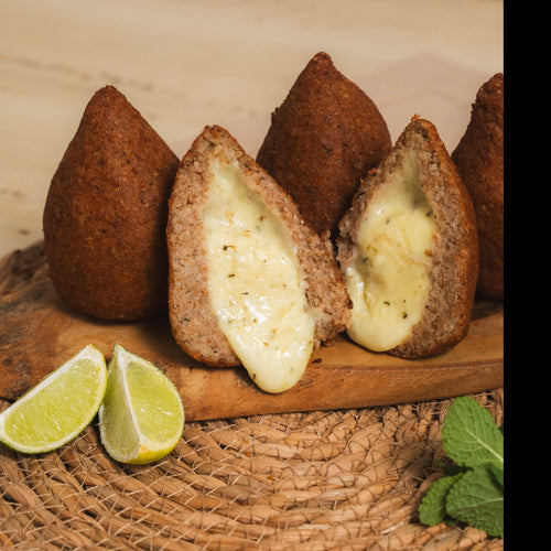 A golden-brown crispy Coxibe croquette cut in half showing a spiced beef bulgur wheat shell and a melted Cheddar and Mozzarella cheese centre.