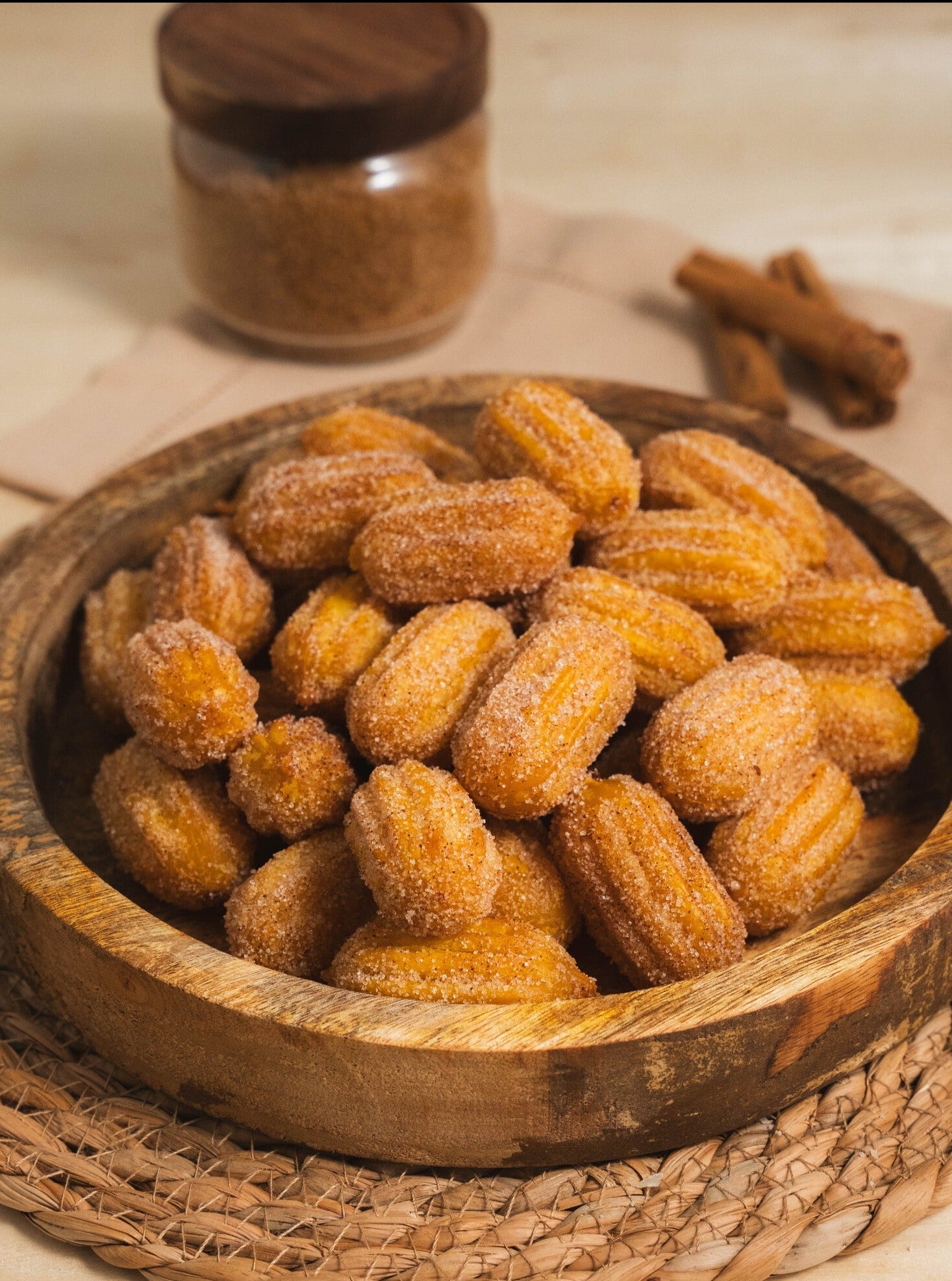 Close-up of golden-brown crispy churros dusted with sugar, showing a rich and melted Dulce de Leche caramel filling bursting inside.