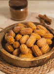 Close-up of golden-brown crispy churros dusted with sugar, showing a rich and melted Dulce de Leche caramel filling bursting inside.
