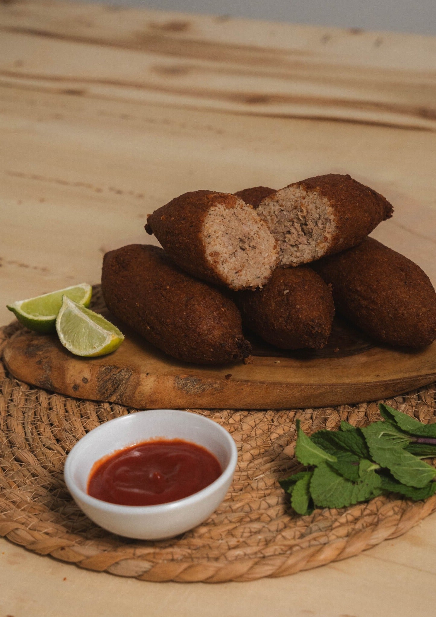 Golden-brown crispy Big Kibe croquette served hot on a plate, seasoned with fresh mint and traditional spices.
